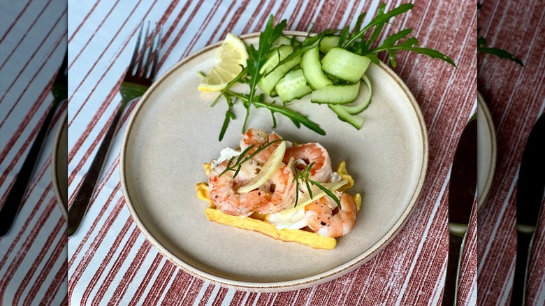 pickled shrimp on toast with lemon slices and arugula