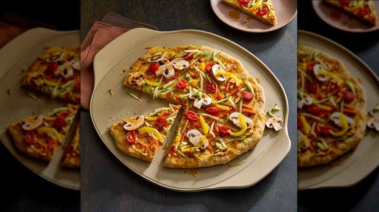 Overhead view of pampered chef ceramic pizza stone with veggie pizza