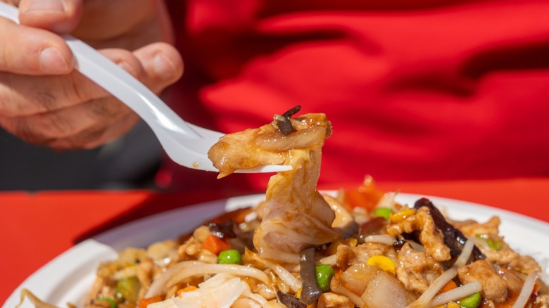 Someone lifting up a plastic fork full of food