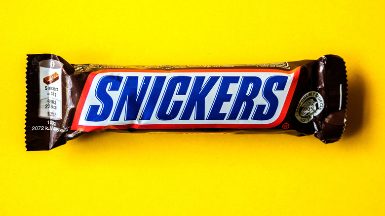 Snickers bar against a yellow background