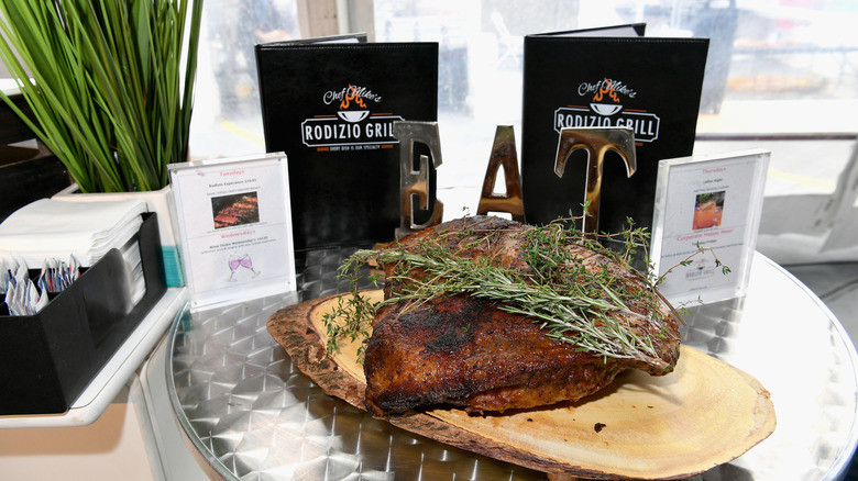 cut of steak in front of Rodizio grill menus