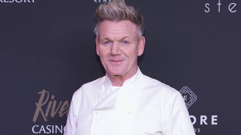 Gordon Ramsay posing for cameras against a dark-colored backdrop.