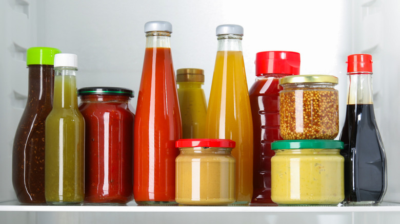 Bottles of sauces and condiments on fridge shelf