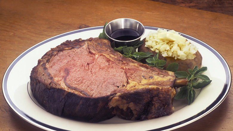 Prime rib and baked potato on a plate