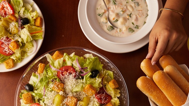 unlimited salad, soup, and breadsticks with person's hand
