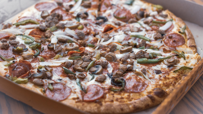 close up of a Little Caesars Ultimate Supreme Pizza in box