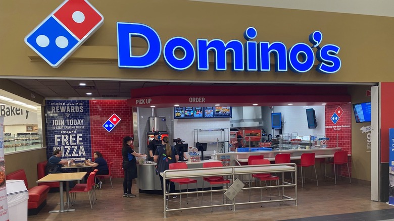 A Domino's location inside of a Walmart with benches and chairs
