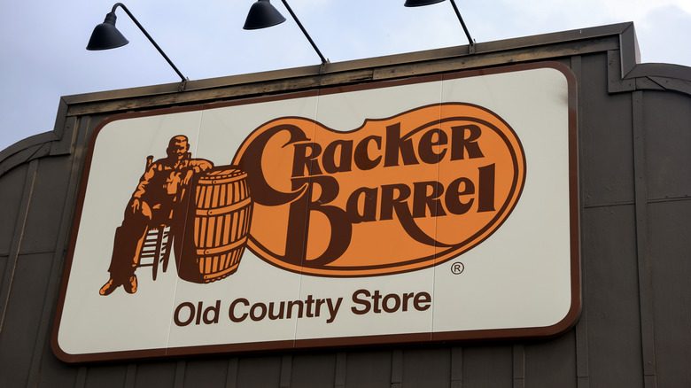 Cracker Barrel sign up close with light overhead, wooden background