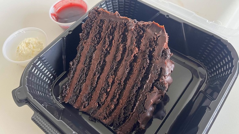 A slice of Outback's Chocolate Tower cake in a black to-go box
