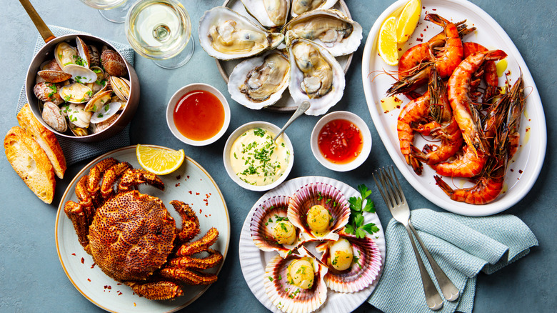 Different types of fresh seafood arranged on plates and platters