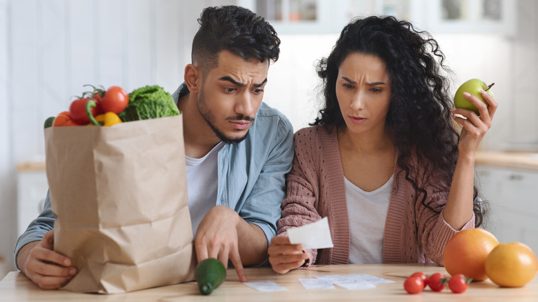 man and woman shocked by grocery prices