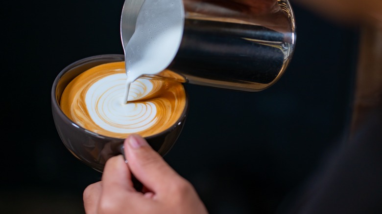 Barista pouring steamed milk