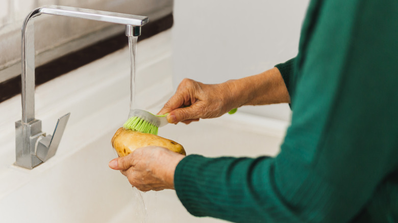 woman scrubbing a potato