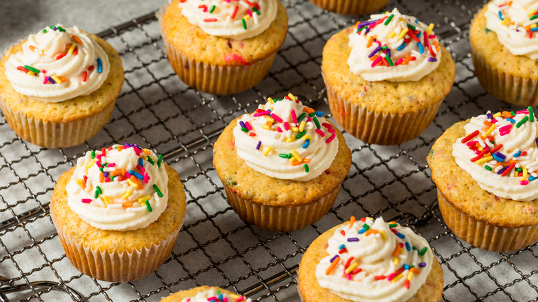 homemade cupcakes with icing and sprinkles on rack