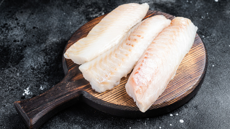 Cod filets on a wooden cutting board