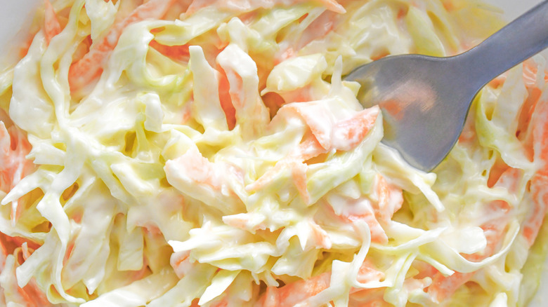 Batch of traditional coleslaw with a spoon in it