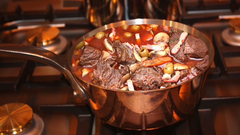 Beef stew in a copper pot on a stove