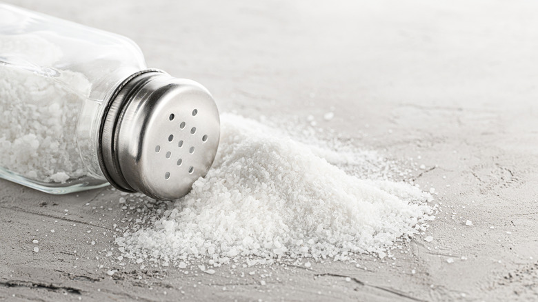 Salt shaker and pile of spilled salt