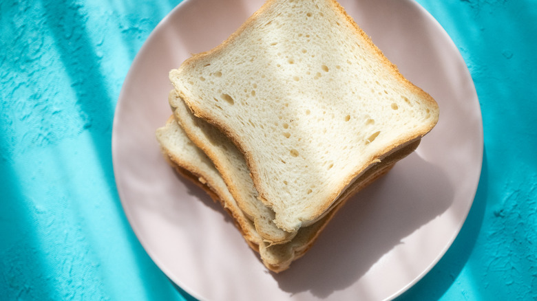 Sliced white bread on pink plate