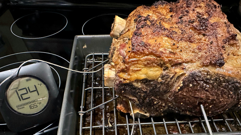 Prime rib in a pan with a meat thermometer inserted