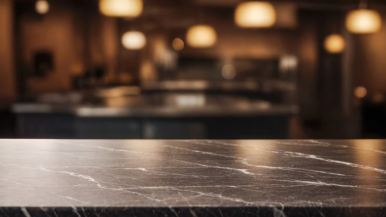 Shiny black soapstone counter inside dimly lit kitchen