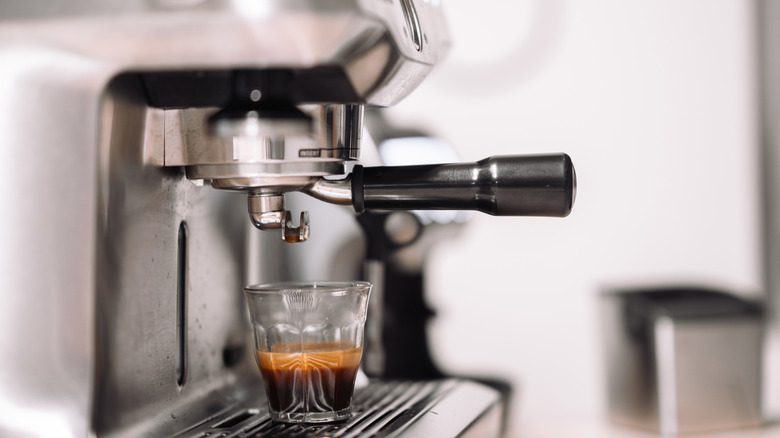 Espresso ina  glass cup on a stainless steel espresso machine
