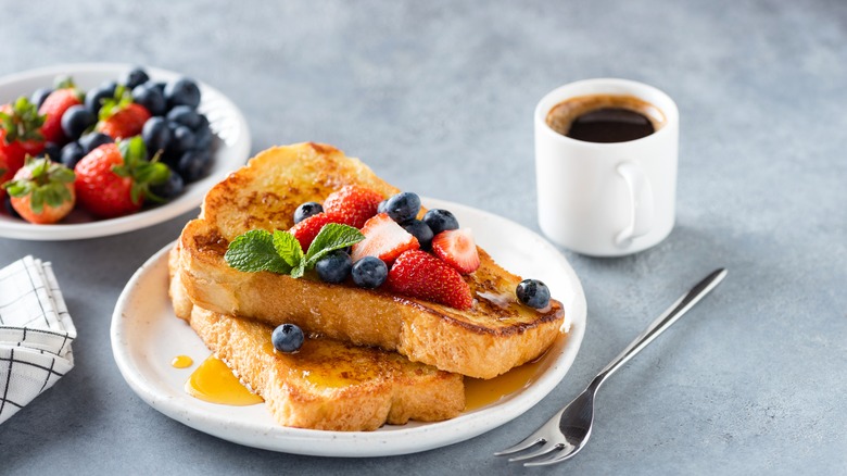 French toast on plate with coffee mug and fruit