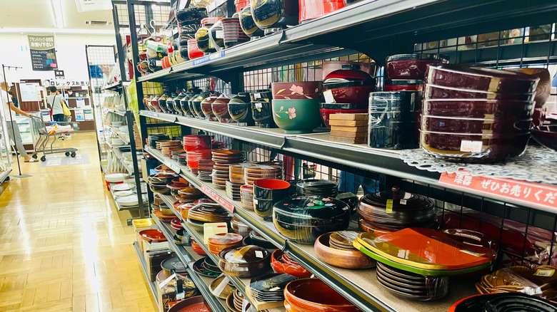 Bowls and plates displayed on the shelves at a thrift store.