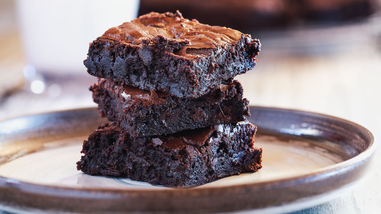 Three brownies stacked on a plate