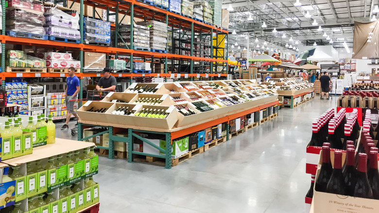 shoppers peruse products in the alcohol section of a Costco store