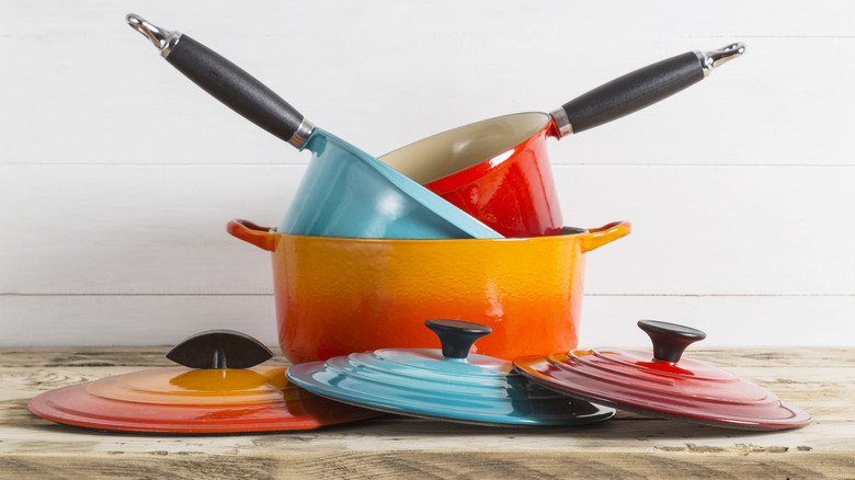 Red, orange, and blue Le Creuset pieces stacked on a countertop