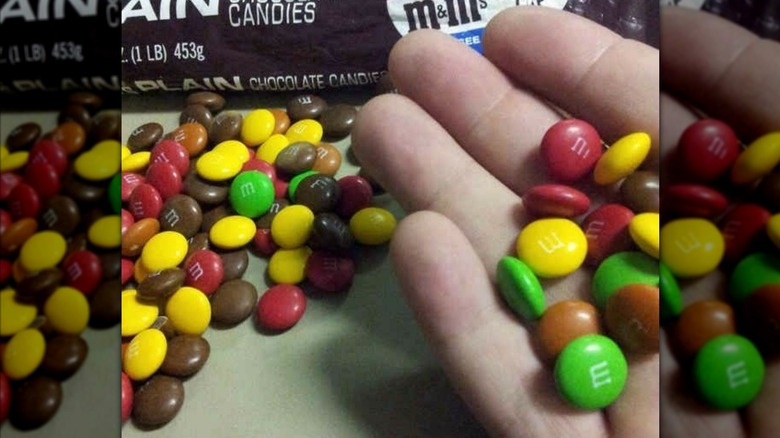 A hand holding vintage M&Ms featuring brown and tan candies