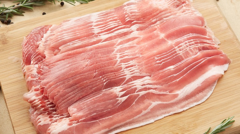 uncooked bacon on cutting board