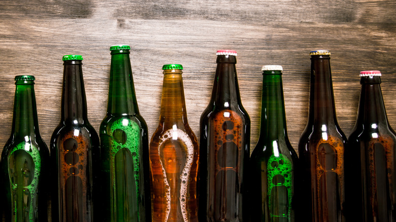 Brown and green beer bottles with a wood background