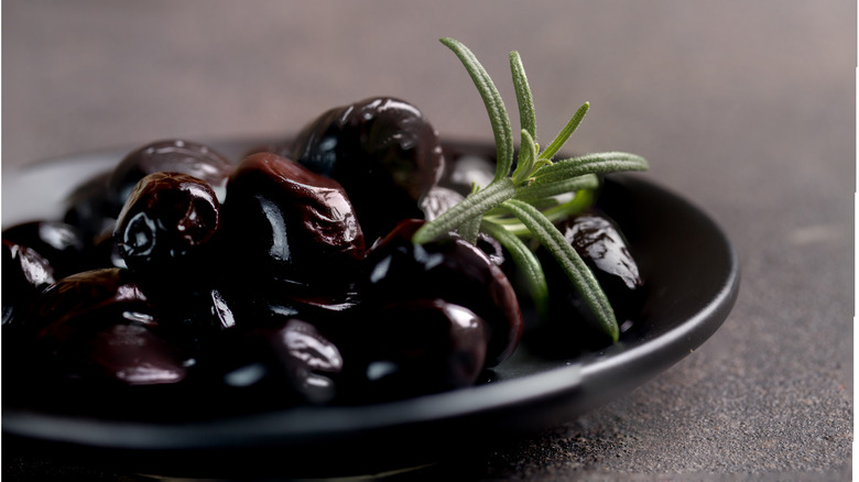Black olives in a pile on plate