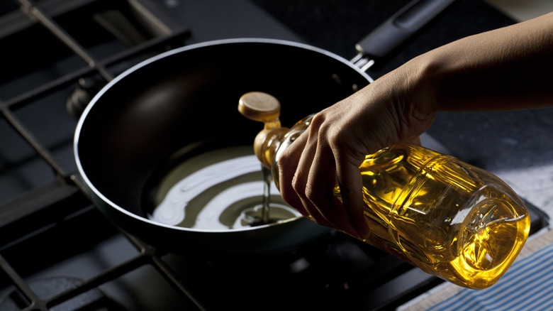 olive oil being poured into a pan