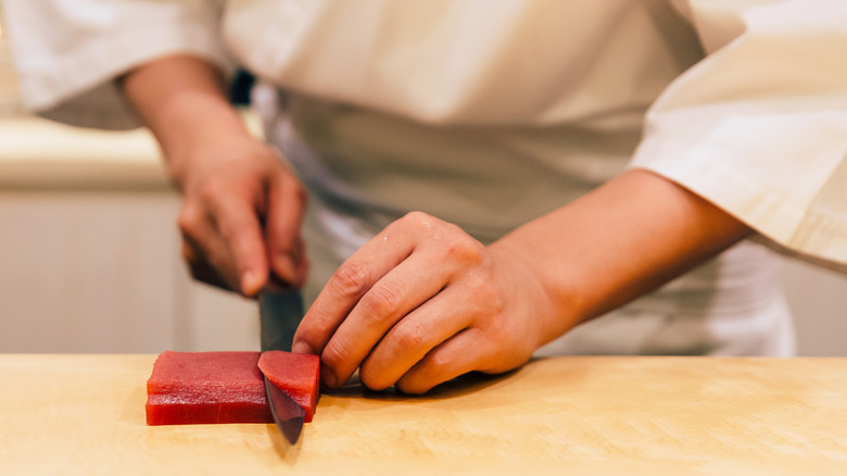 hands cutting sushi