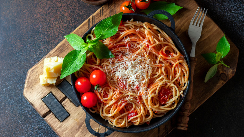 Spaghetti in pan with fresh garnishes