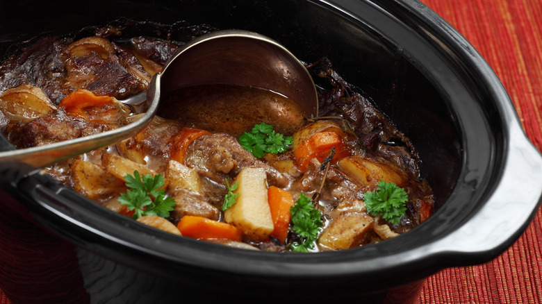 slow cooker with beef, potatoes, and carrots