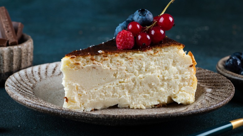 A moist slice of cheesecake with a fresh fruit garnish on a plate