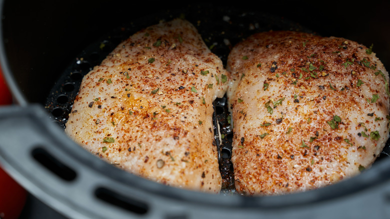 Two chicken breasts about to be cooked in an air fryer