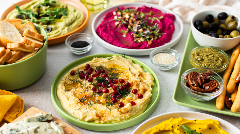 selection of vegan food like hummus and bread with spices and nuts