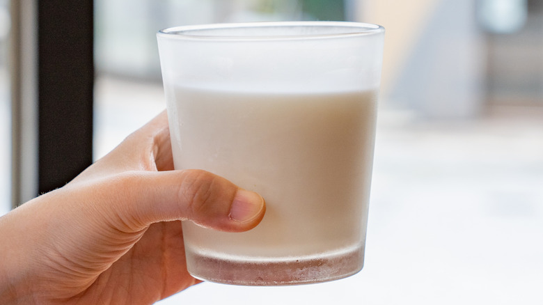 Hand holding glass of milk
