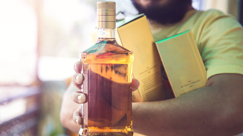Indian man with whisky bottle