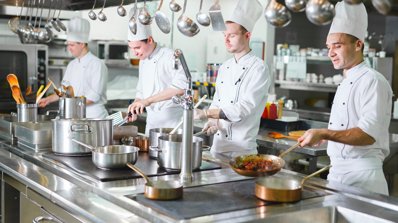 Four chefs in a professional kitchen