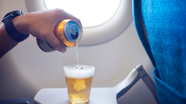 man pouring beer on flight