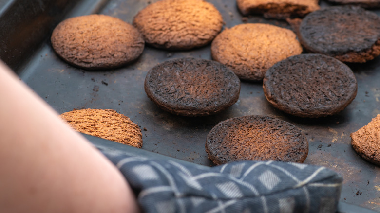 black baking tray with burnt cookies