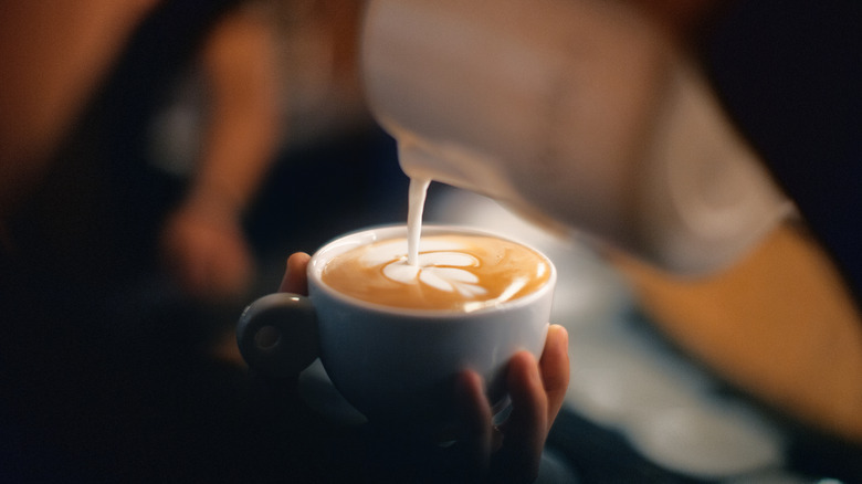 Hand holding a cappuccino