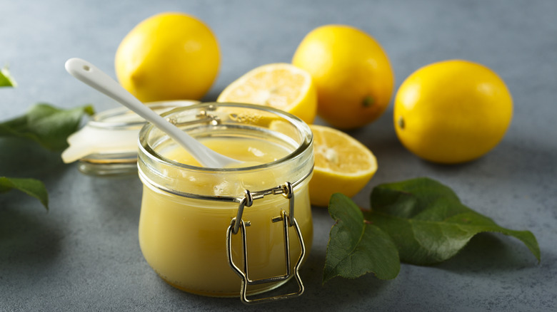 jar of lemon curd with slices lemons and leaves
