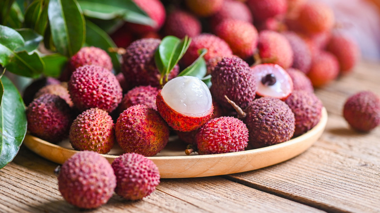 Lychees on wood plate with portion of tree